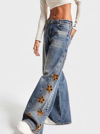Blue floral embroidered wide-leg jeans from Trendsi, showing intricate floral embroidery and relaxed fit style.