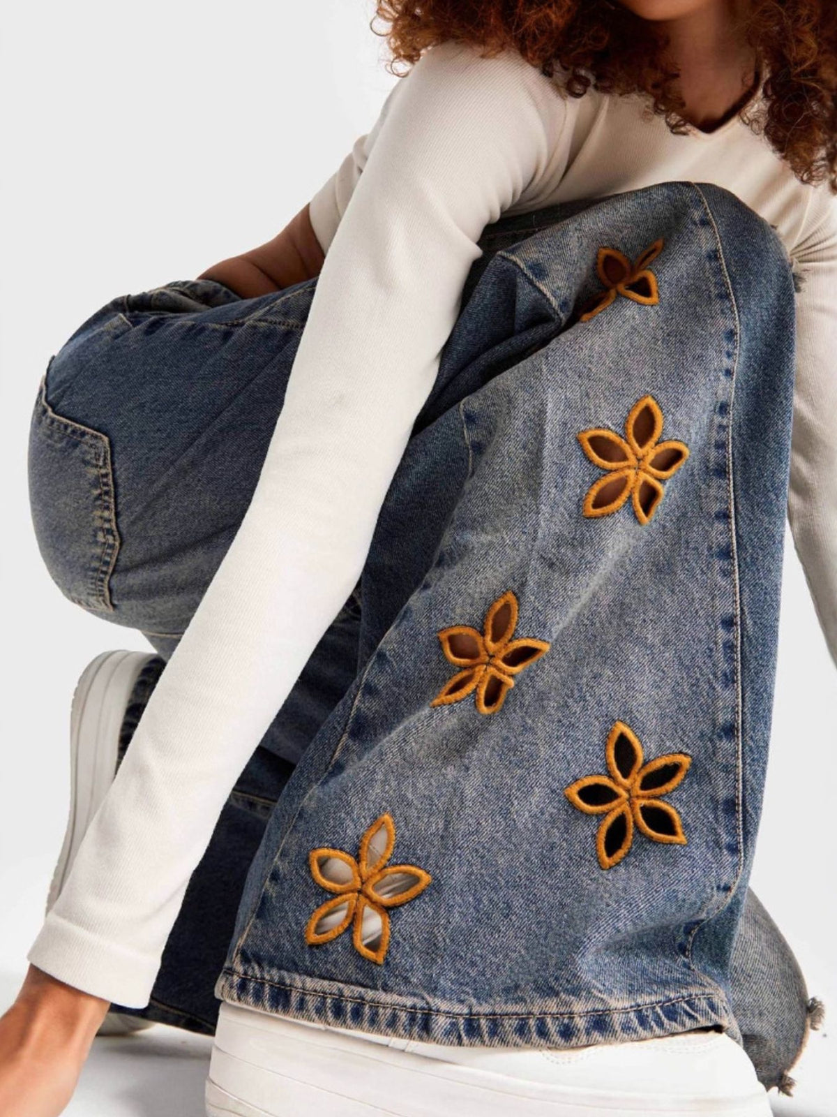 Blue floral embroidered wide-leg jeans by Trendsi, featuring intricate embroidery and a relaxed fit, displayed on a plain background.