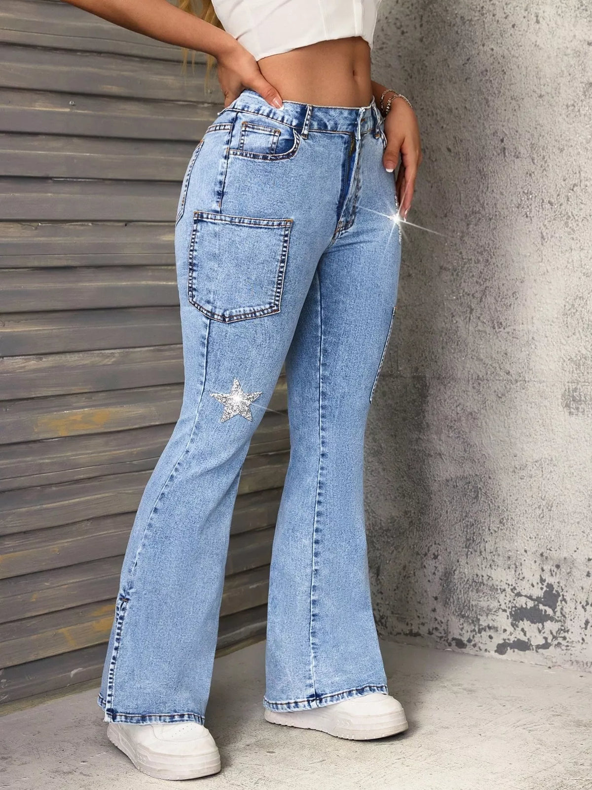 Blue slit star flare leg jeans from Trendsi featuring a stylish star pattern and flared design.