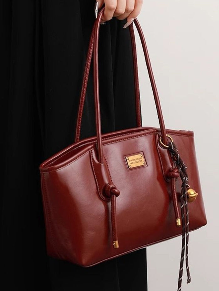 Leather shoulder bag with knot detail from Trendsi, featuring a stylish design and adjustable strap in a natural leather finish.