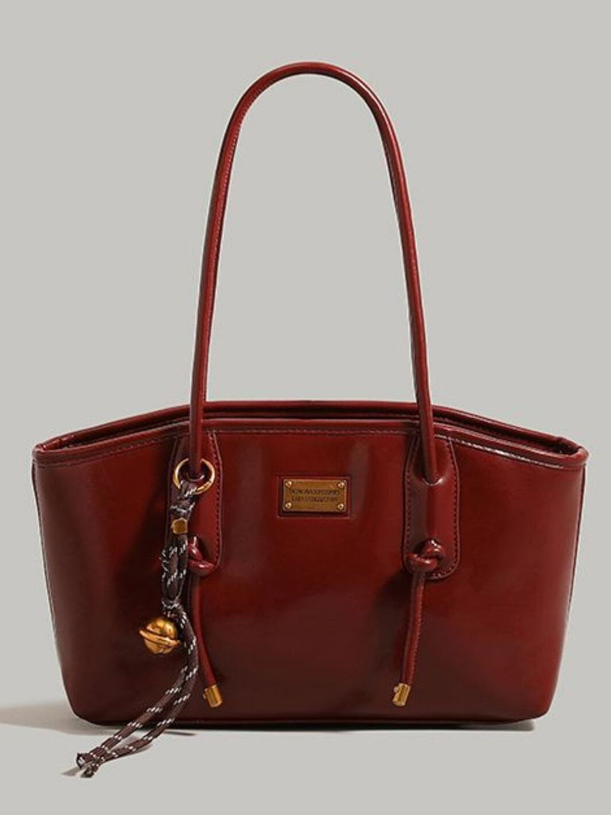 Leather shoulder bag with knot detail from Trendsi, featuring a stylish design and adjustable strap on a neutral background.