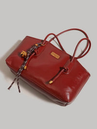 Leather shoulder bag with knot detail from Trendsi, featuring a sleek design and adjustable strap for stylish everyday use.