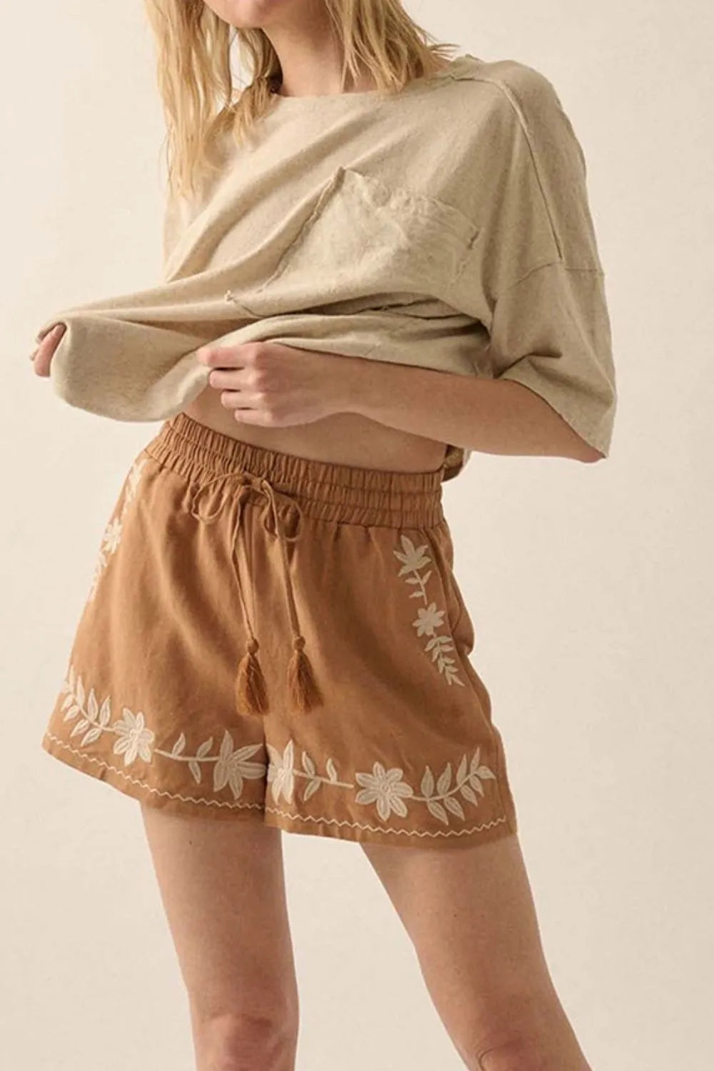 Embroidered boho-style casual shorts with tasseled drawstring and elastic waist in caramel color, trendy and comfortable for summer wear.