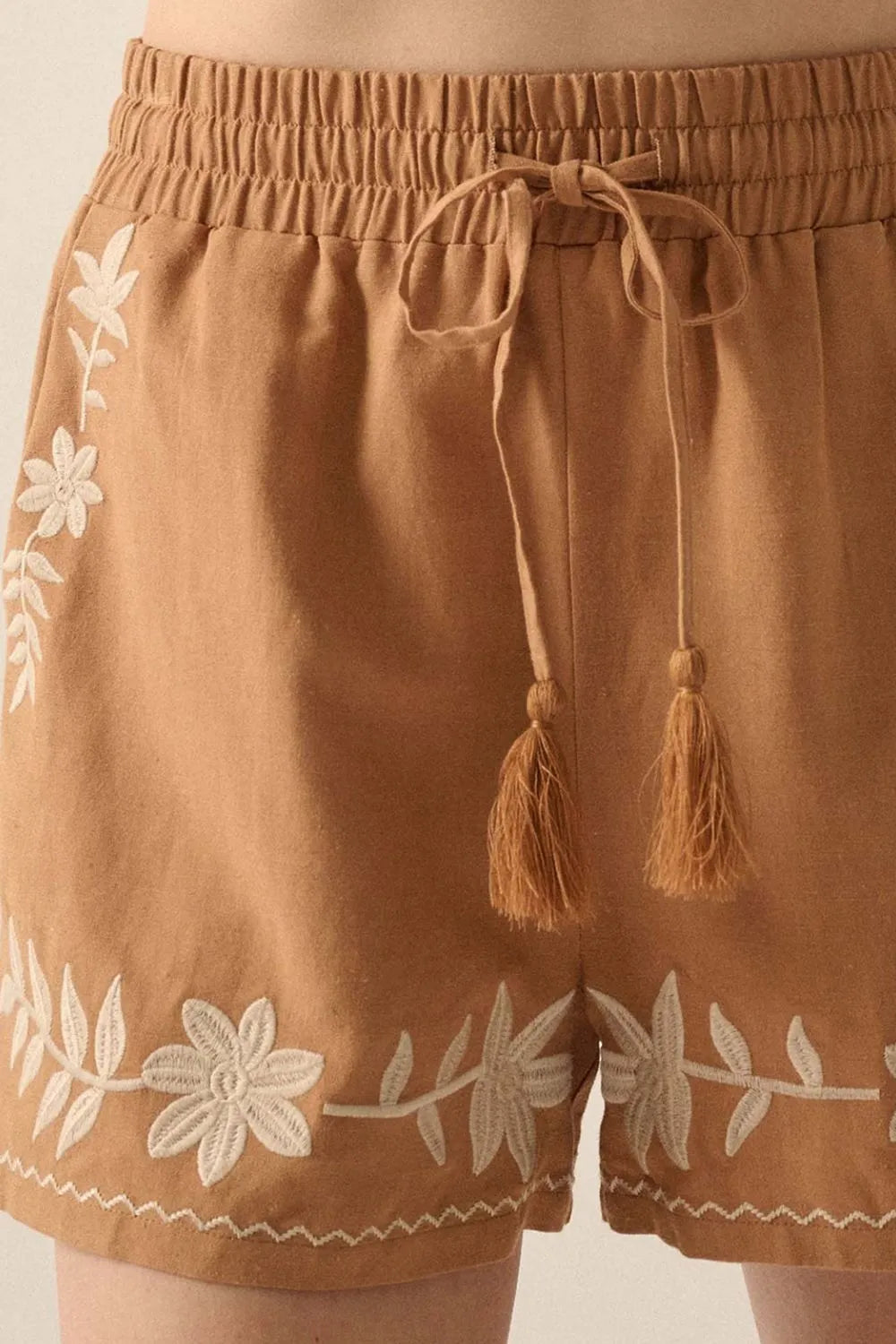 Embroidered boho casual shorts with tasseled drawstring and elastic waist in caramel color, featuring intricate embroidery details.