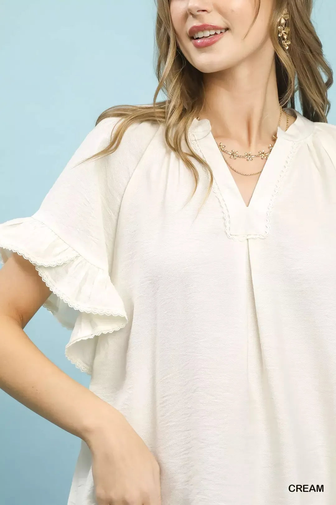 Umgee ruffle sleeve v-neck flutter blouse with feminine design and soft fabric, styled on a model.