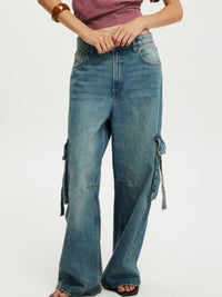 Vintage wash wide leg cargo jeans from Trendsi with large side pockets and relaxed fit, shown on a model.