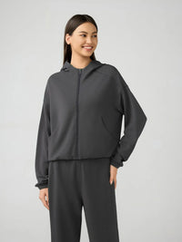 Trendsi Millennia zip-up active hoodie with dropped shoulders, hood, and athletic fit, shown in black with front zipper and casual style.