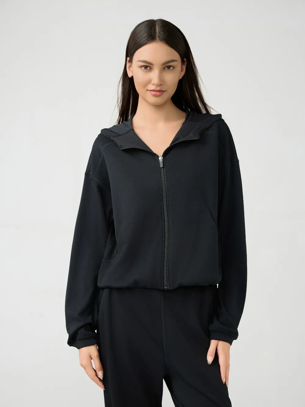 Millennia zip-up dropped shoulder active hooded sweatshirt by Trendsi, showing front view with hood and zip closure.