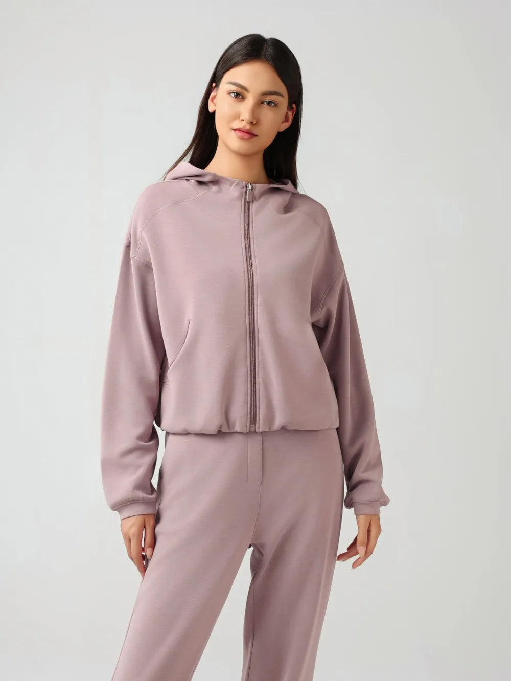 Trendsi Millennia zip-up hoodie with dropped shoulders, active fit, hood, and zip front, shown in a stylish, casual pose.