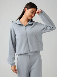 Trendsi Millennia zip-up active hoodie with dropped shoulders, hood, and front pockets, made of soft, comfortable fabric.