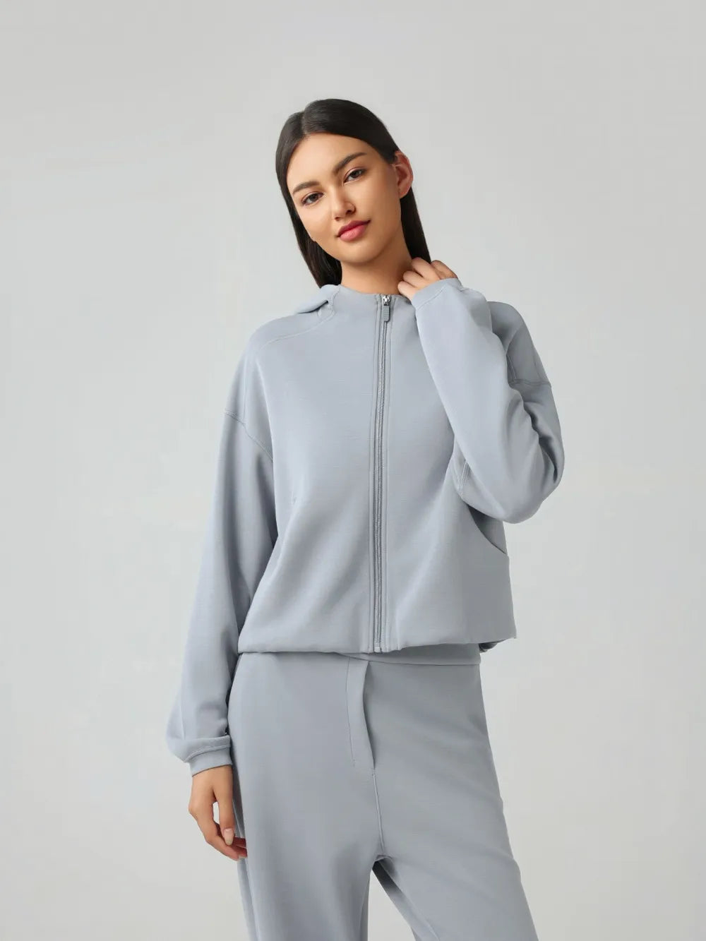 Trendsi Millennia zip-up hoodie with dropped shoulders, active fit, and hood, shown in dark color with front zipper and casual style.
