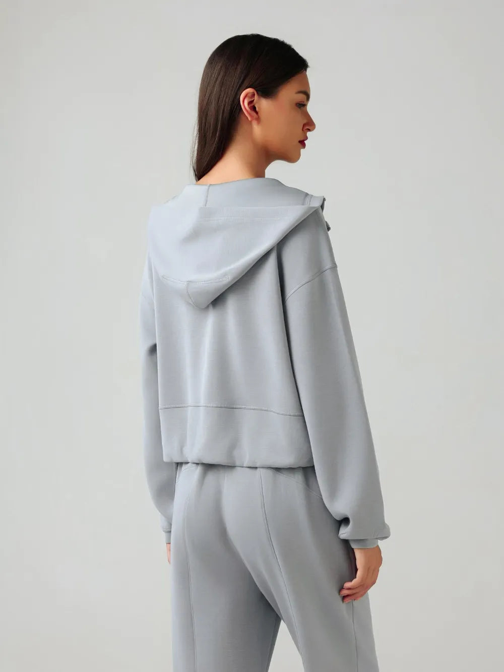 Trendsi Millennia zip-up active hoodie with dropped shoulders, hood, and front pockets, black color, casual athletic style.