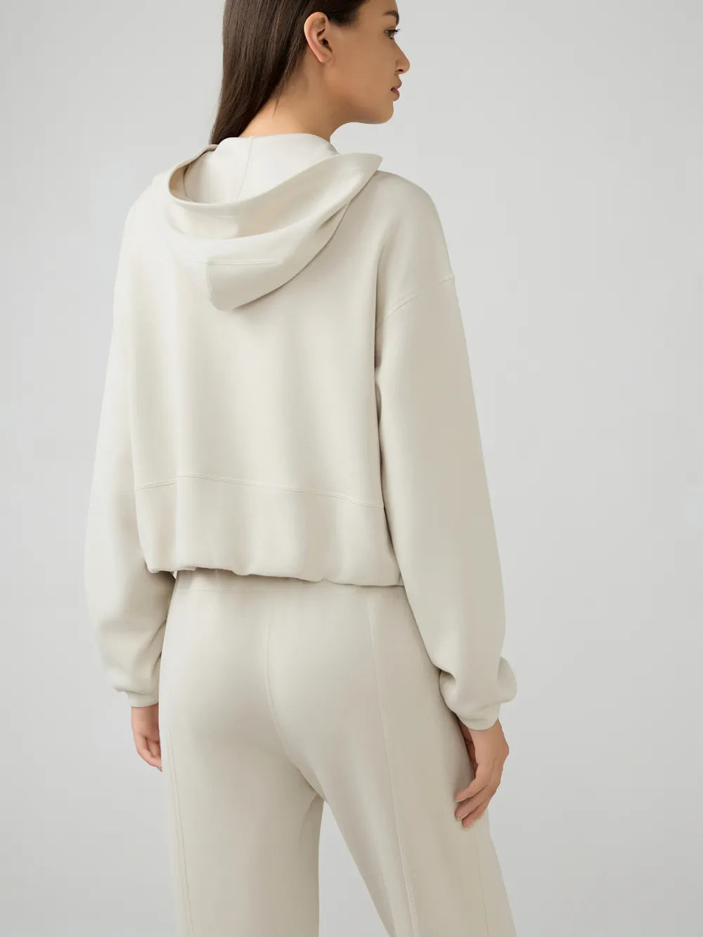 Trendsi Millennia zip-up active hoodie with dropped shoulders, hood, and front pockets, in a stylish casual design.
