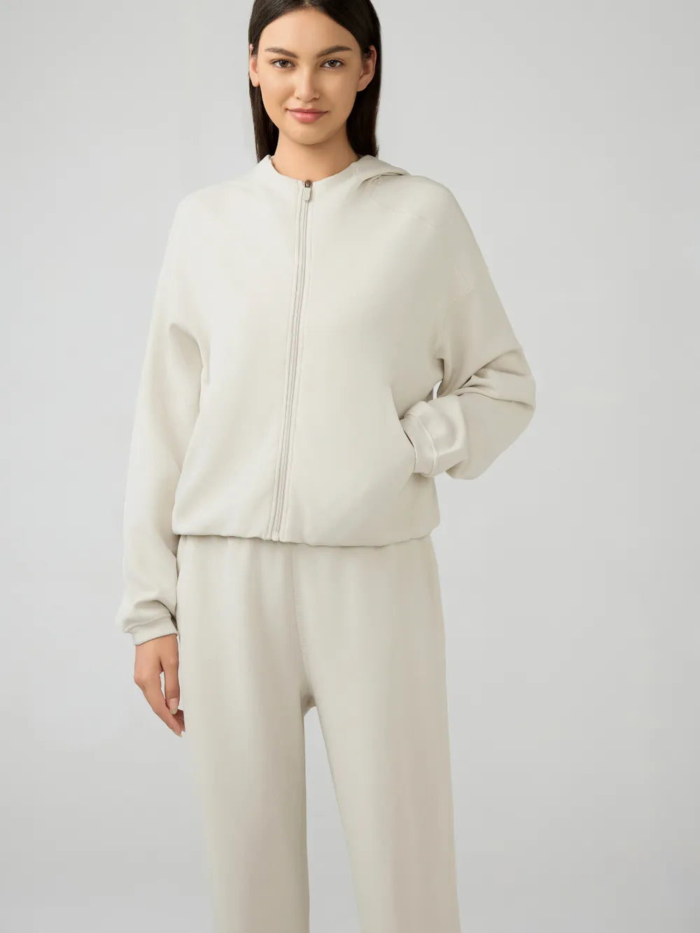 Trendsi Millennia zip-up active hoodie with dropped shoulders, hood, and front pockets, in a casual, stylish design.