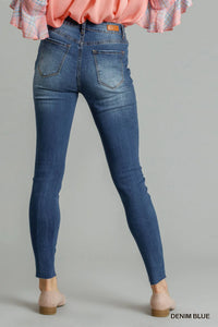 Blue distressed skinny jeans by Umgee with front pockets, fitted style, casual denim look, shown on a model.