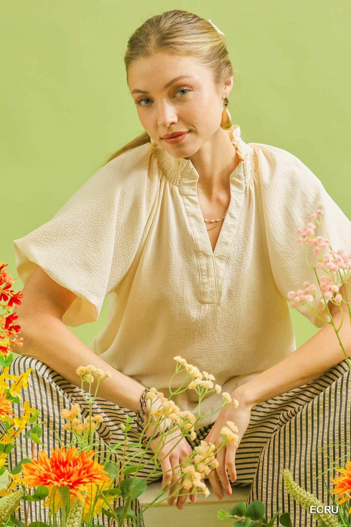 Textured Umgee scalloped hem blouse with long sleeves and intricate detailing, displayed on a hanger.