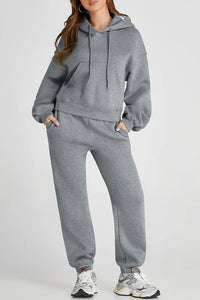 Dropped shoulder hooded top and matching active pants set by Trendsi, featuring a relaxed fit and comfortable athletic style.