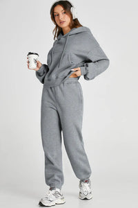 Dropped shoulder hooded top and pants active set by Trendsi, featuring a relaxed fit with a hood and casual style, shown in black.