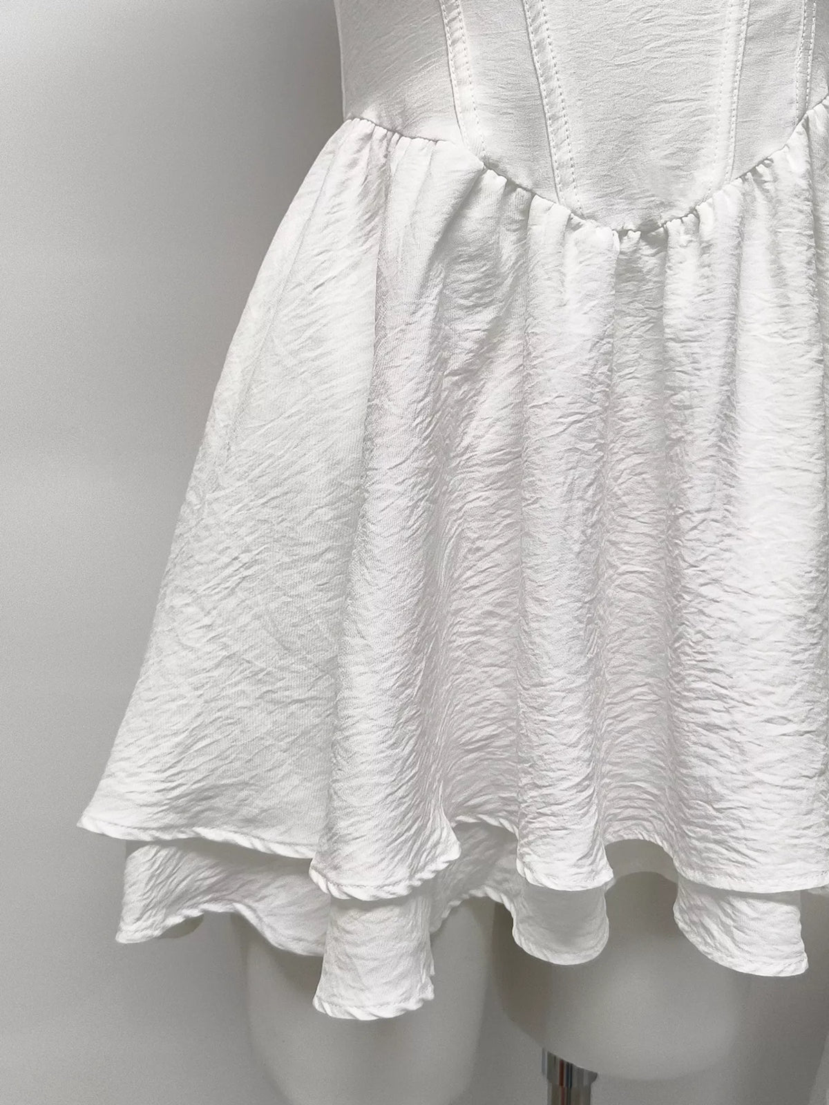 Gray and white ruffle-trimmed layered mini dress by Trendsi, featuring a stylish and playful design with ruffle accents.