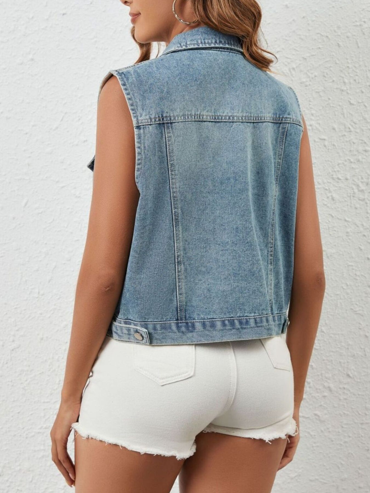 Light blue sleeveless denim jacket by Trendsi with rhinestone embellishments, showcasing a stylish, casual look.