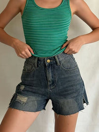 Distressed slit denim shorts by Trendsi featuring frayed hems and ripped details, styled on a model for a casual summer look.