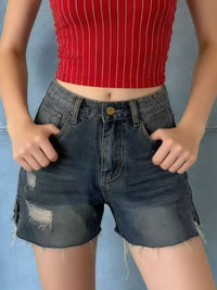 Distressed slit denim shorts by Trendsi featuring a frayed hem, high waist, and ripped details, styled for casual summer wear.