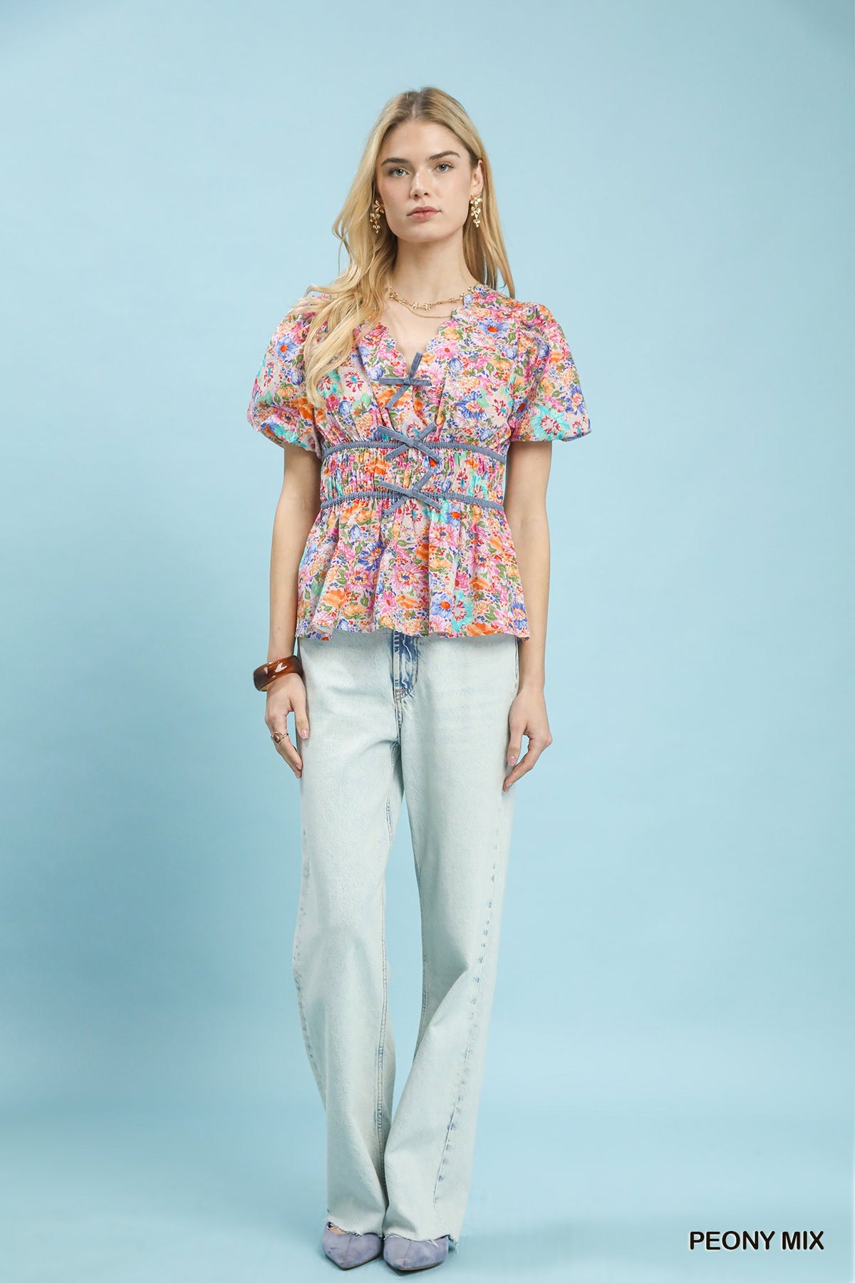 Umgee floral smocked waist blouse featuring a mix of colorful floral patterns and a relaxed fit, perfect for casual wear.