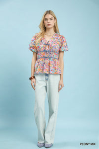 Umgee floral smocked waist blouse featuring a mix of colorful floral patterns and a relaxed fit, perfect for casual wear.