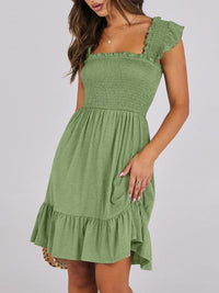 Sage green smocked ruffle hem mini dress by Trendsi, featuring a fitted bodice, ruffled hem, and short sleeves, styled for summer.