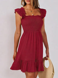 Sage green smocked ruffle hem mini dress by Trendsi, featuring a fitted bodice, ruffled hem, and sleeveless design.