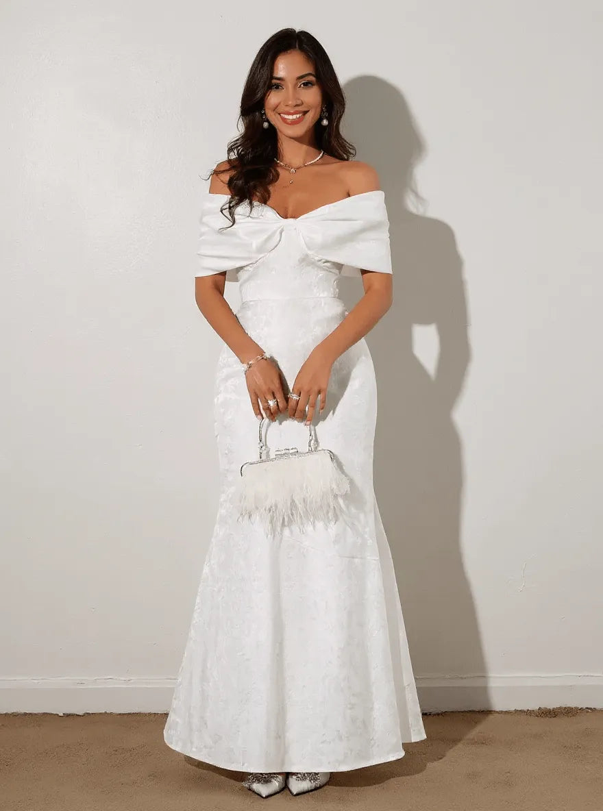 Off-shoulder maxi dress by Trendsi featuring a bow detail, flowing fabric, and a stylish, elegant design perfect for summer wear.