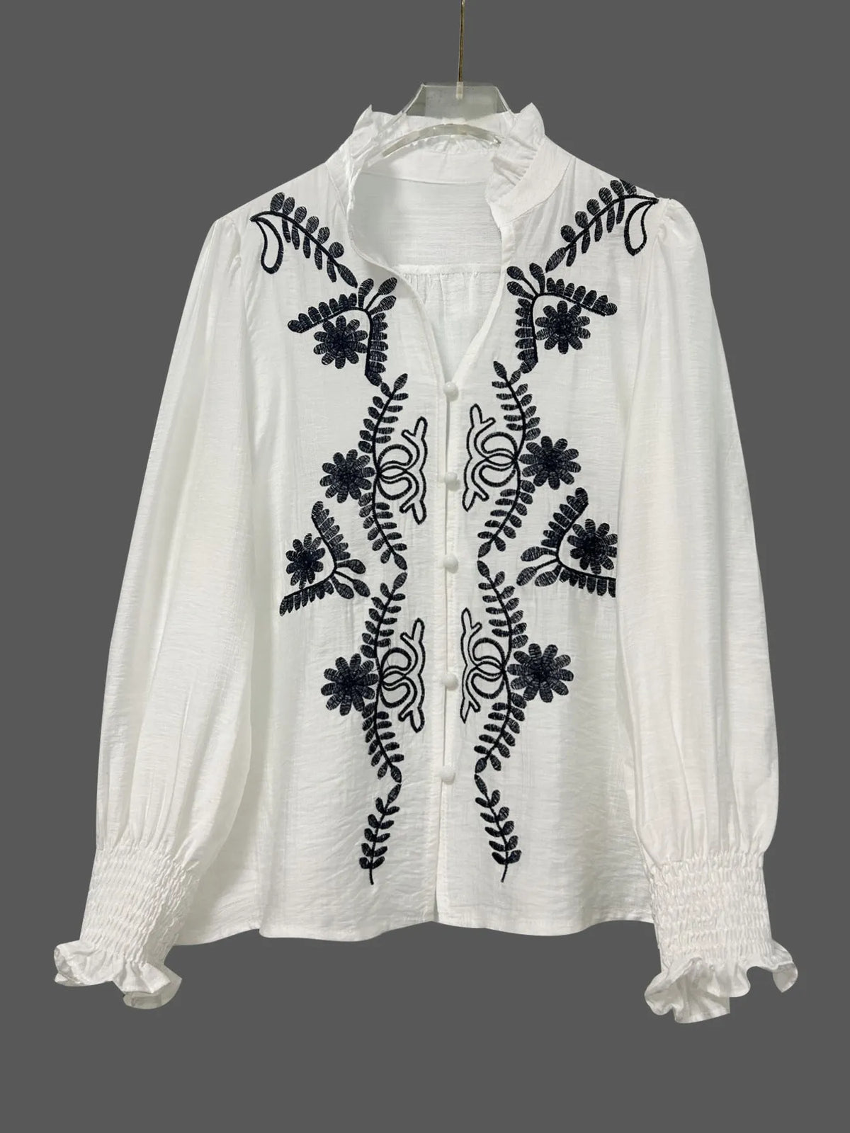 Embroidered long sleeve blouse by Trendsi, featuring intricate embroidery and a relaxed fit, shown on a model.