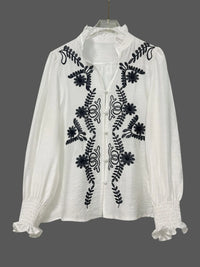 Embroidered long sleeve blouse by Trendsi, featuring intricate embroidery and a relaxed fit, shown on a model.