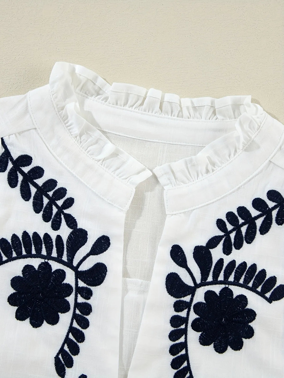 Embroidered long sleeve blouse from Trendsi featuring intricate embroidery, lightweight fabric, and a relaxed fit.