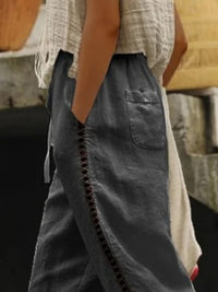 Hollow out trim cropped pants from Trendsi with stylish cut-out design, high-waisted fit, and lightweight fabric for a modern look.