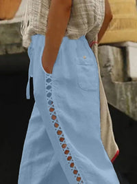 Hollow out trim cropped pants by Trendsi featuring a stylish cut-out design and relaxed fit, shown in a neutral fabric.