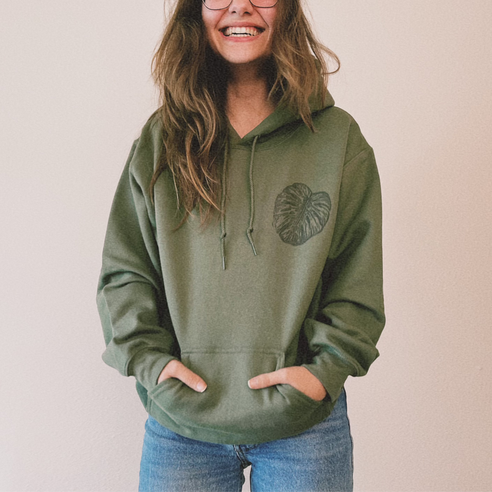 Olive green Monstera hoodie by VesperTwine featuring a tropical leaf design, made from soft fabric with a cozy fit.