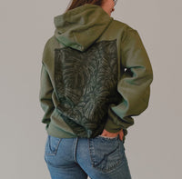 Olive green Monstera hoodie by VesperTwine featuring a Monstera leaf print on soft fabric.