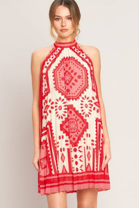 Voglio.us printed halter mini dress with vibrant floral pattern, sleeveless design, and fitted waist on model.