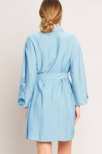 Soft blue belted shirt dress from voglio.us, featuring a collared neckline, long sleeves, and a waist belt for a stylish look.