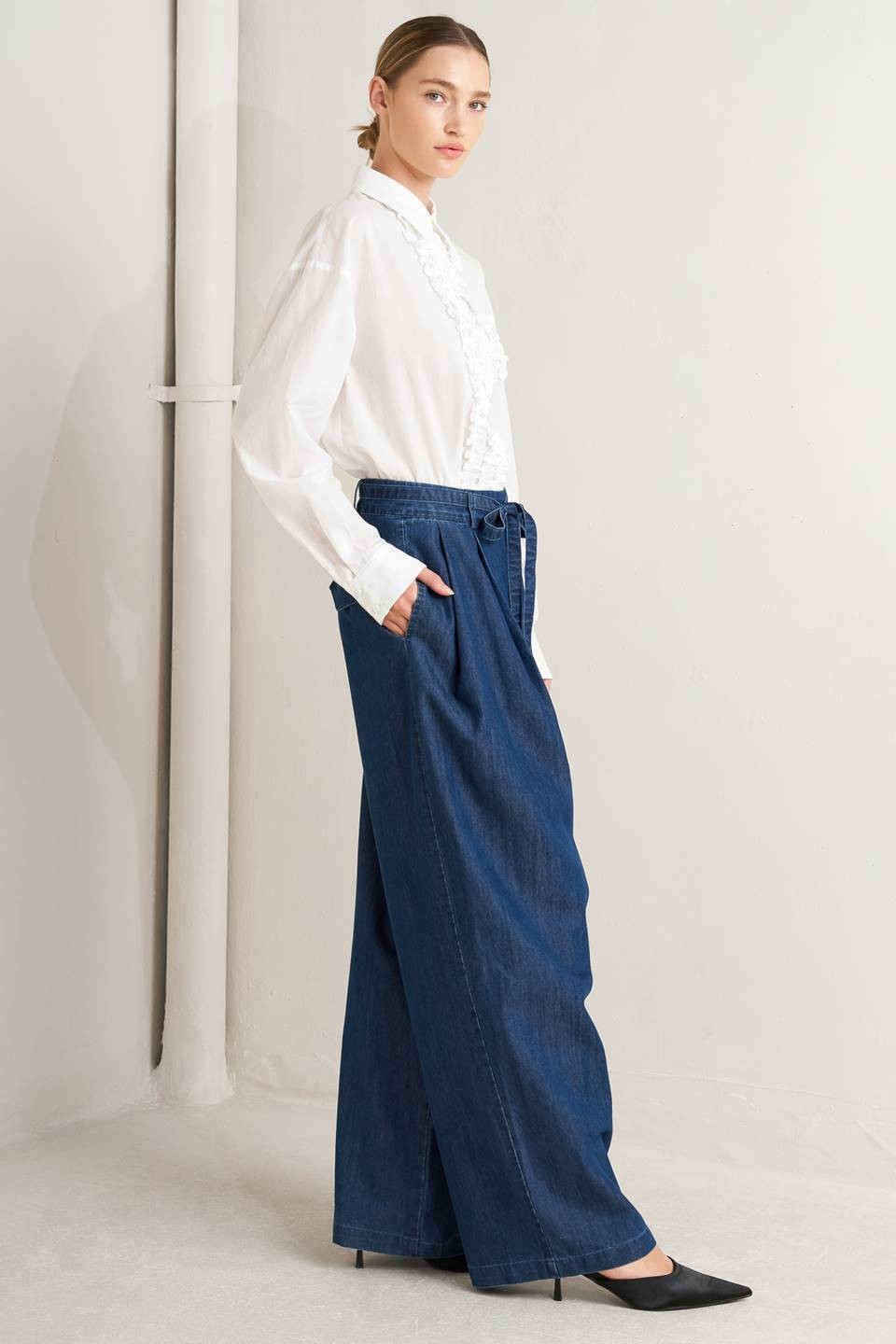 Light washed denim crossover waist jeans by voglio.us, featuring a relaxed fit and classic denim texture.