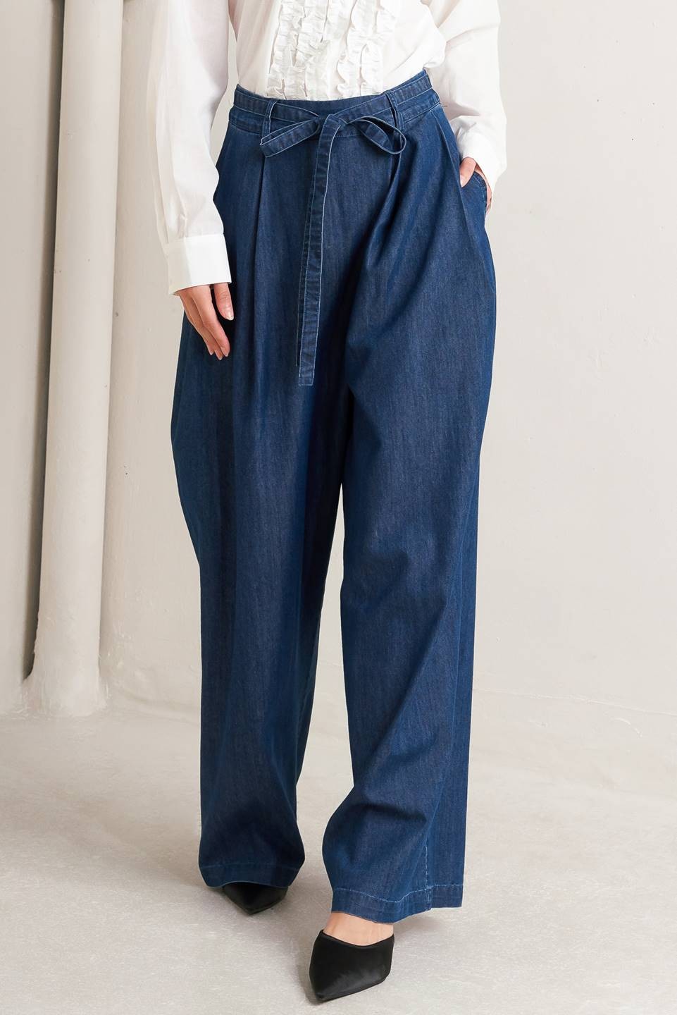 Light blue washed denim jeans with a crossover waist design from voglio.us, casual fit, styled on a model.