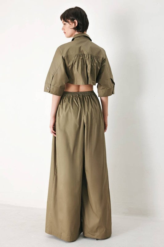 Olive green utility jumpsuit by voglio.us featuring multiple pockets and a relaxed fit, displayed on a hanger.