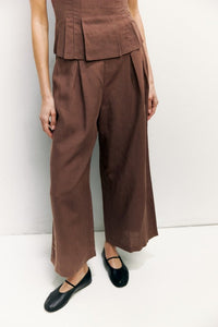 Light beige Jocelyn linen blend wide-leg pants with a relaxed fit and high waist, styled with a white top.