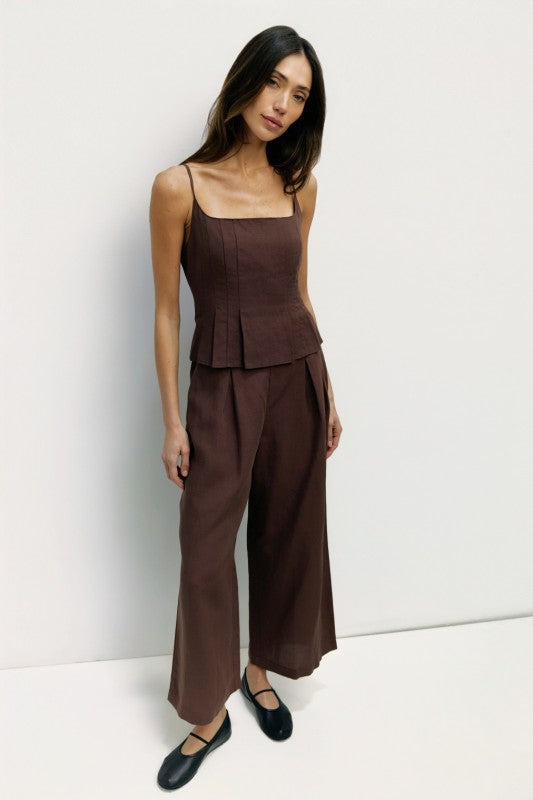 Light beige Jocelyn linen blend wide-leg pants by voglio.us hanging on a rack, showcasing their flowy, relaxed fit and wide-leg style.