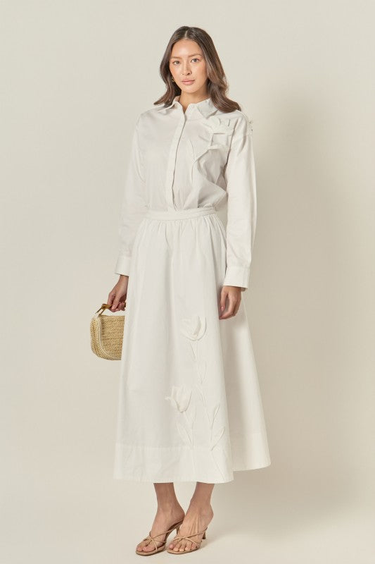 Appliqued accent midi skirt from voglio.us featuring colorful embroidery and a flowing silhouette, styled on a model.