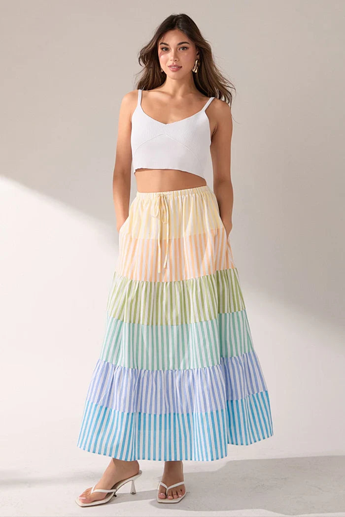 Striped color block tiered maxi skirt from voglio.us, featuring flowing fabric and bold horizontal stripes in various colors.