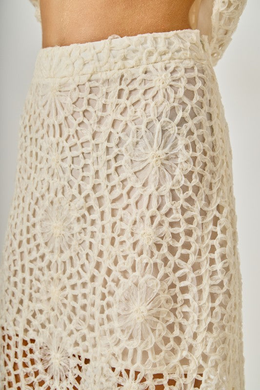 Textured voglio.us midi skirt showing a high-waisted, flowy design with a detailed fabric pattern.
