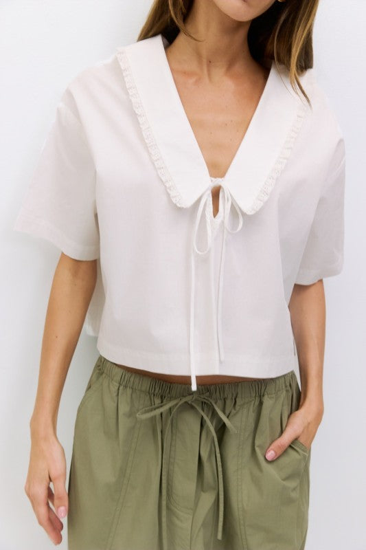 Voglio.us Roseanne V-neck tie-front top in soft pink fabric, featuring a stylish V-neck and front tie detail.