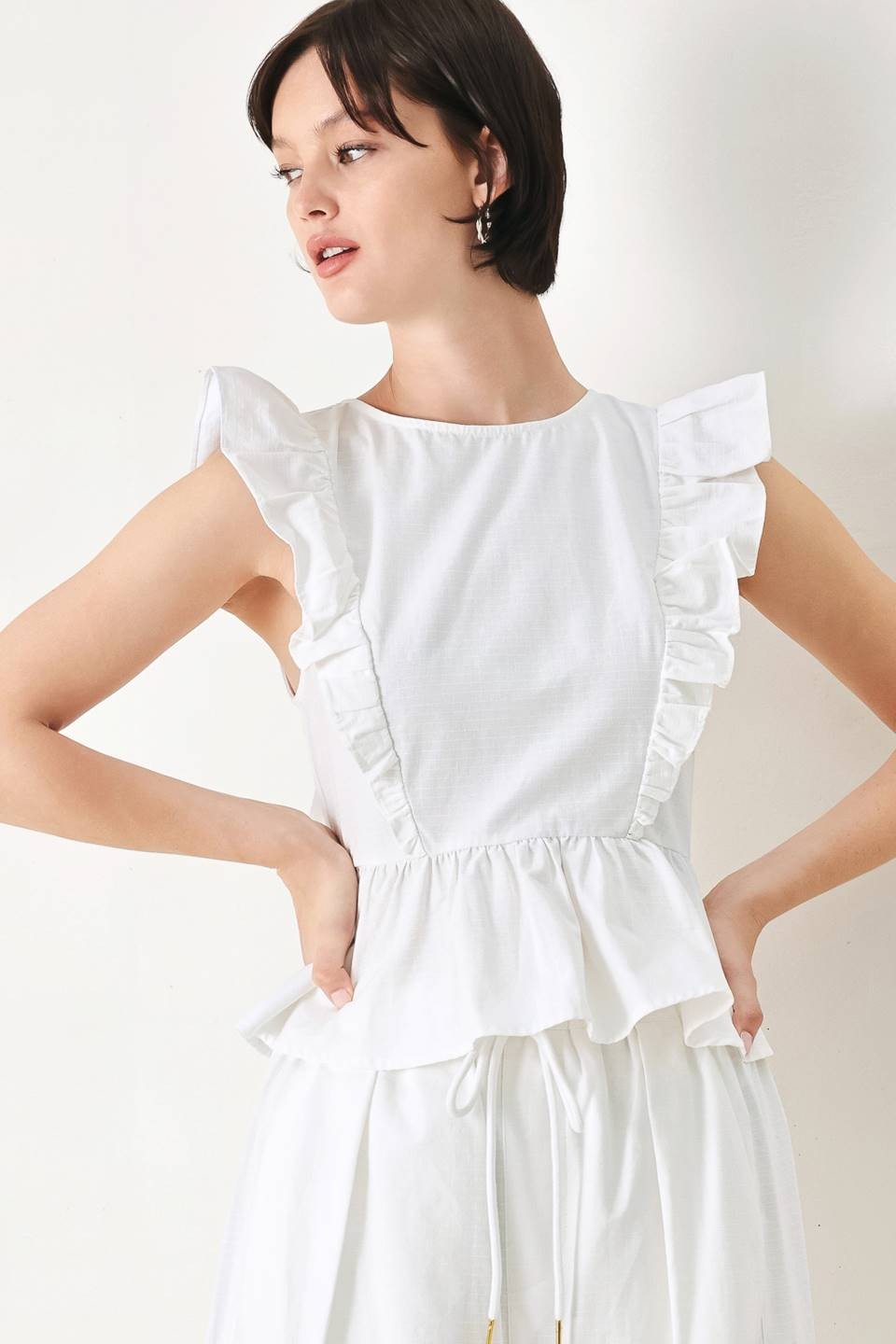 Cotton peplum top with ruffle shoulder detail from voglio.us, featuring a fitted bodice and flared hem.